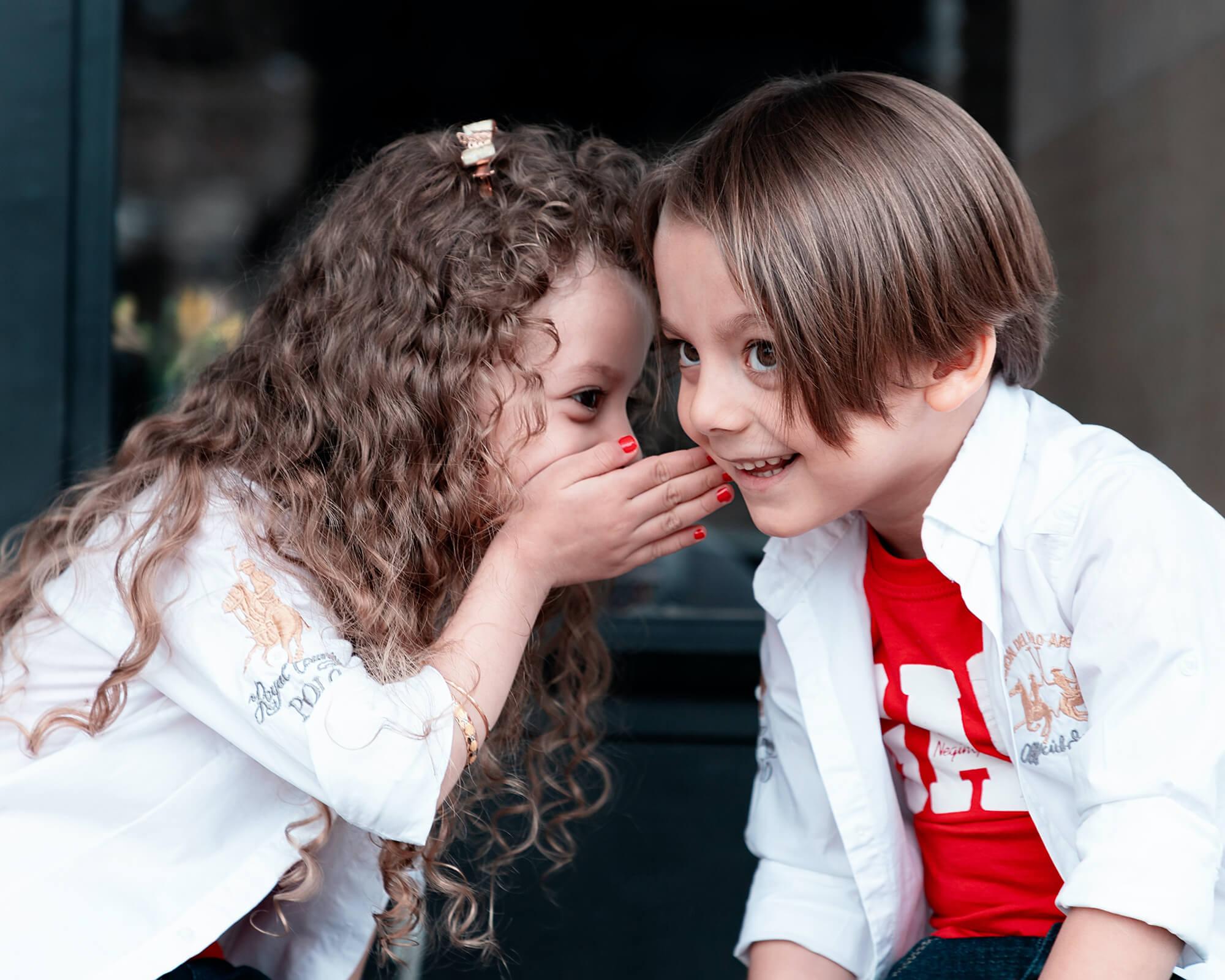 Kinder flüstern sich etwas zu